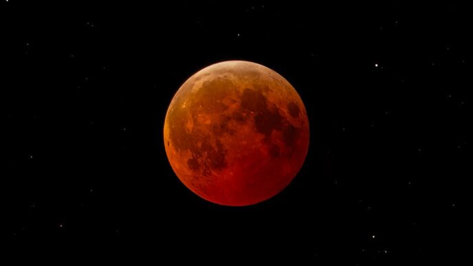 Esta cautivadora imagen captura una luna de sangre durante un eclipse lunar total contra un cielo nocturno estrellado.