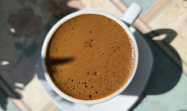 Fotografía macro de café turco con rica espuma, capturada en un día soleado en Nicosia, Chipre.