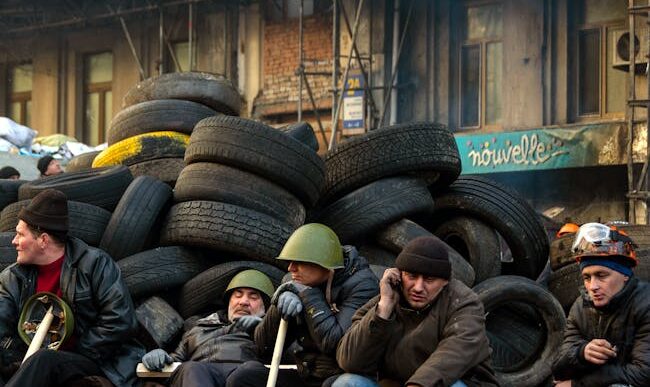 Manifestantes sentados junto a barricadas de neumáticos durante los disturbios civiles en Kyiv, Ucrania.